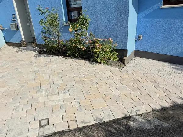 Fertige Fläche mit neu bepflanztem Beet vor dem Haus