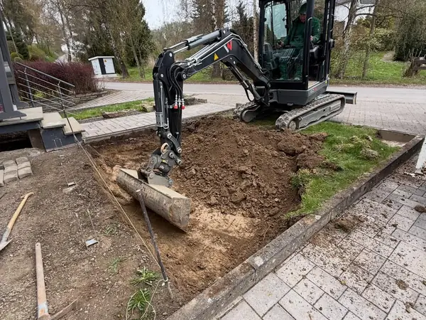 Schritt 1: Minibagger schachtet die Fläche neben dem alten Pflaster aus