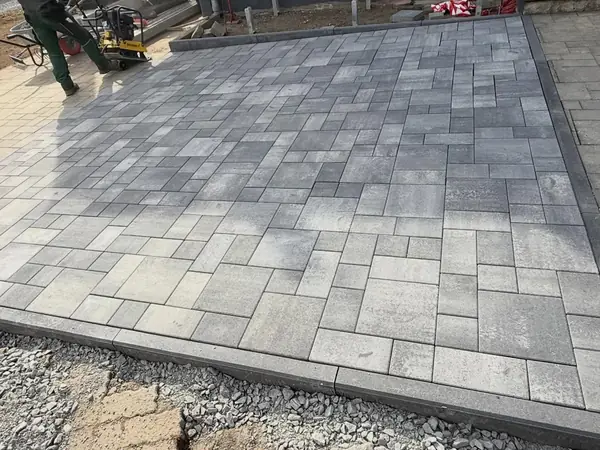 Schritt 3: die fertig verlegte graue Pflasterfläche vor dem Haus