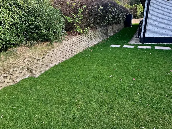 Dicht angewachsener Rollrasen mit Trittplatten und Böschungssteinen
