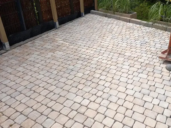 Fertig verlegte Pflasterfläche mit Sichtschutzwand