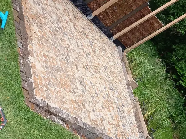 Fertige Fläche aus Kleinpflaster von oben, darüber die Pergola
